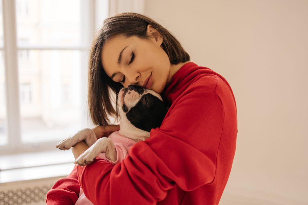 A woman hugging her healthy puppy that is fed a raw diet